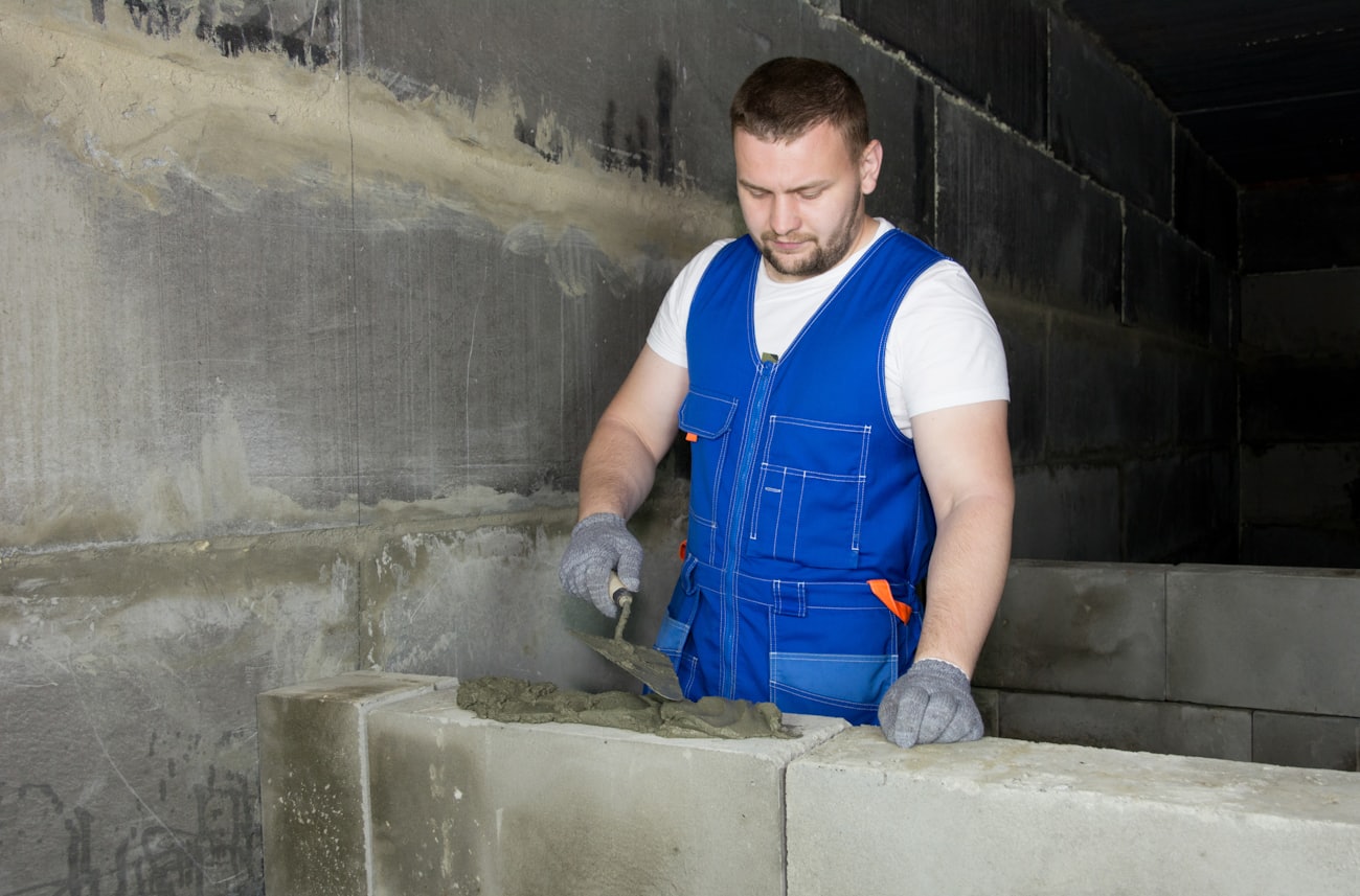 Operario construyendo un muro de bloques